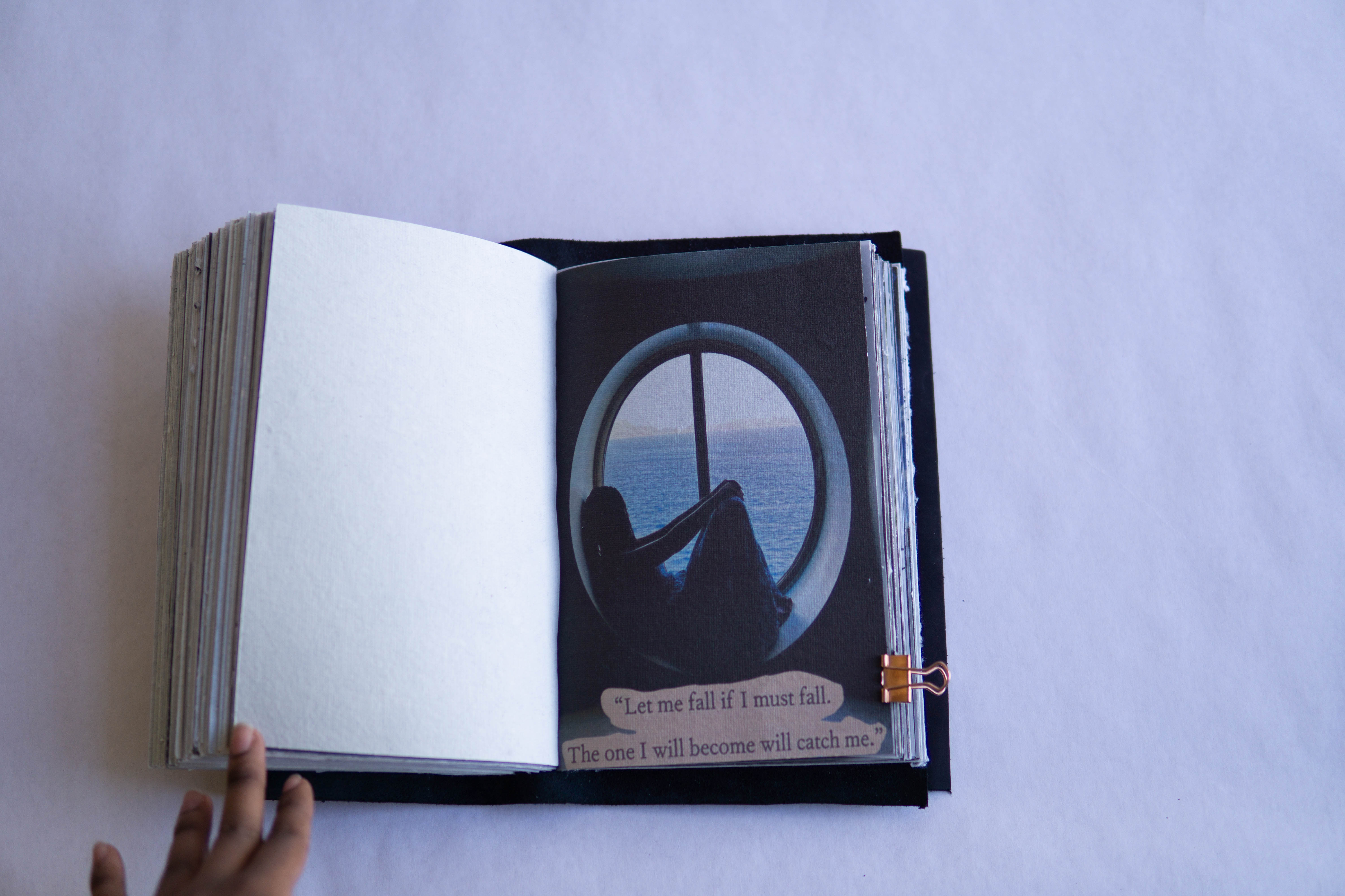 Close-up of a book spread featuring a circular window image with layered text beneath, highlighting mixed media composition